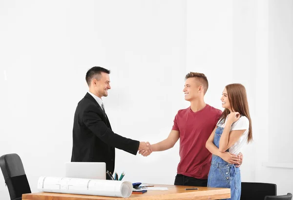 Hombre estrechando la mano con agente inmobiliario en la oficina —  Fotos de Stock