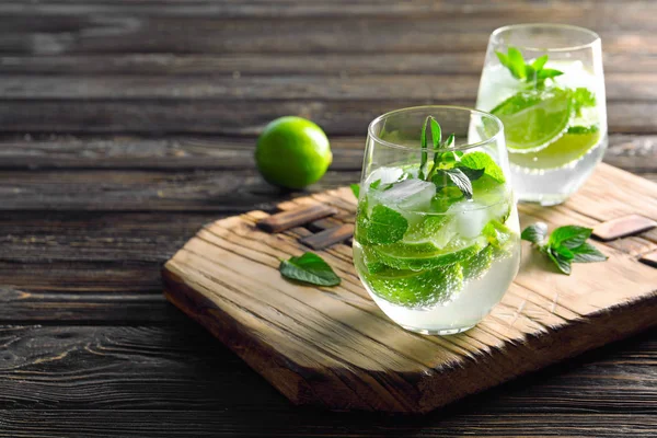 Glasögon av cocktail med mynta och lime på träskiva — Stockfoto