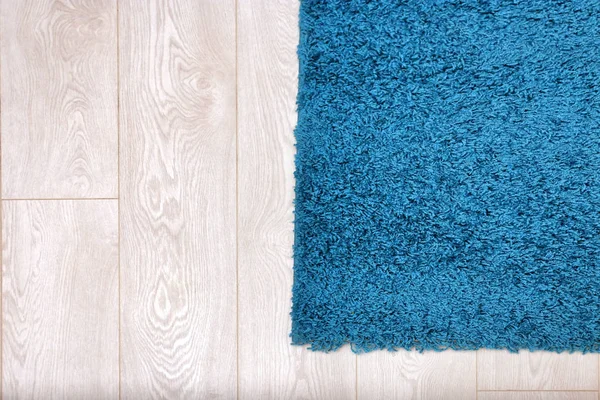 Hermosa alfombra azul en el suelo de madera —  Fotos de Stock