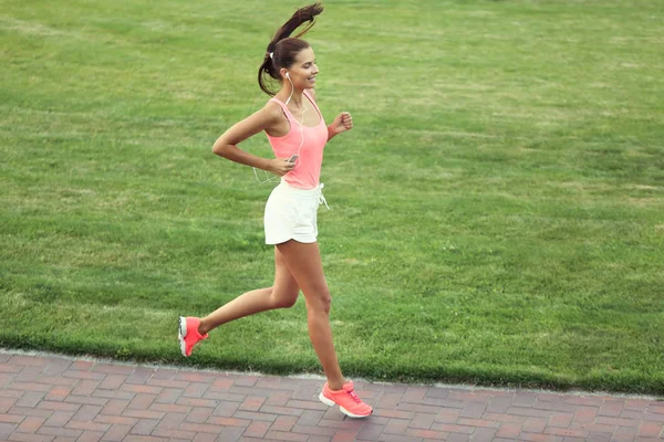 Спортивная молодая женщина бегает в парке — стоковое фото