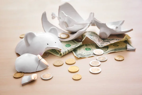 Gebroken spaarvarken bank met geld op lichte achtergrond — Stockfoto