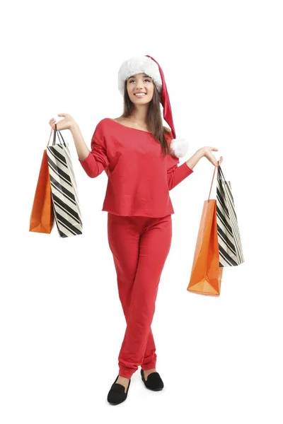 Young woman in Santa hat holding colorful shopping bags on white background. Boxing day concept — Stock Photo, Image