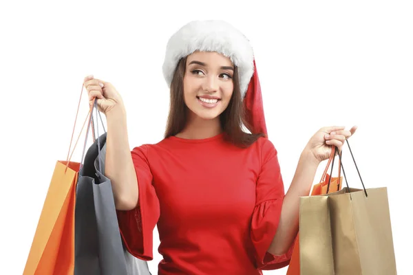 年轻的妇女在圣诞老人帽子藏品五颜六色的购物袋在白色背景。装箱日概念 — 图库照片