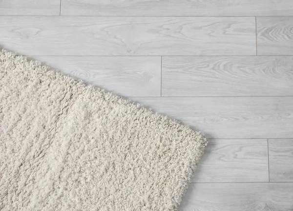 White soft carpet on wooden floor, closeup — Stock Photo, Image