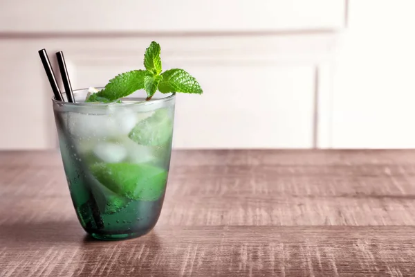 Glas av cocktail med lime och mynta på träbord — Stockfoto