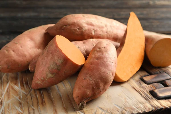 Zoete aardappelen op houten bord — Stockfoto