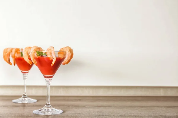 Glasses with shrimp cocktail and tomato sauce on table — Stock Photo, Image