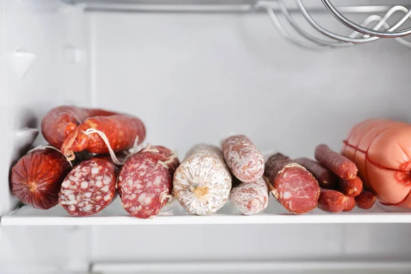 Smakowite kiełbaski na półce w lodówce — Zdjęcie stockowe