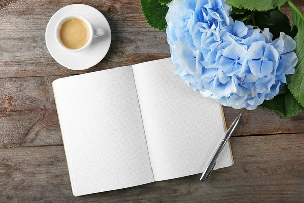 Schöne Blumen mit Notizbüchern und einer Tasse Kaffee — Stockfoto
