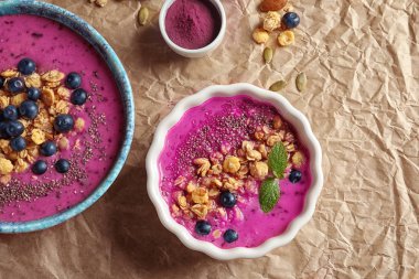 Acai güler yüzlü, çilek ve müsli kağıt üzerinde kaseler