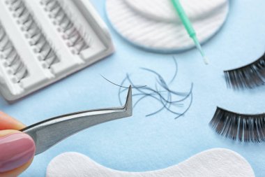 Arka plan bulanık üzerinde sahte kirpik cımbızla