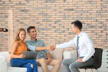 Erkek Emlakçi ve genç çift yeni daire satın alma