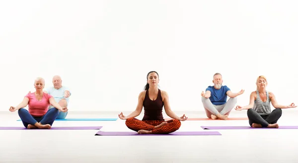 Gruppo di uomini e donne maturi a lezione di yoga al chiuso — Foto Stock