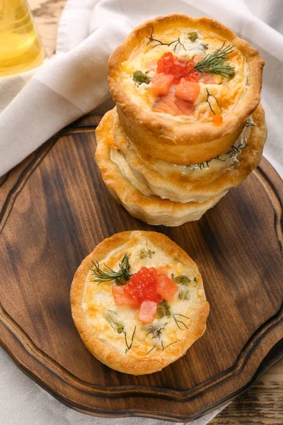 Board with tasty salmon tartlets on table — Stock Photo, Image