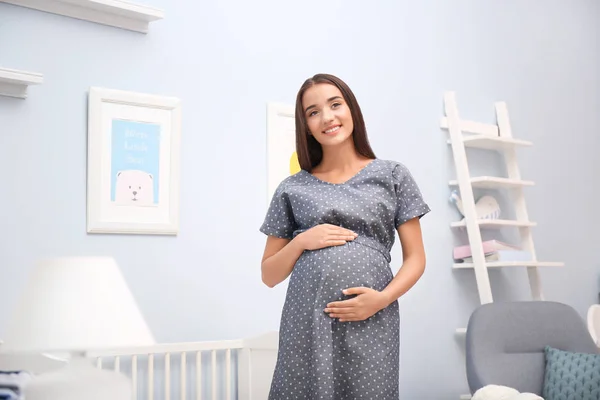 Wanita hamil berdiri di dekat tempat tidur bayi di rumah — Stok Foto