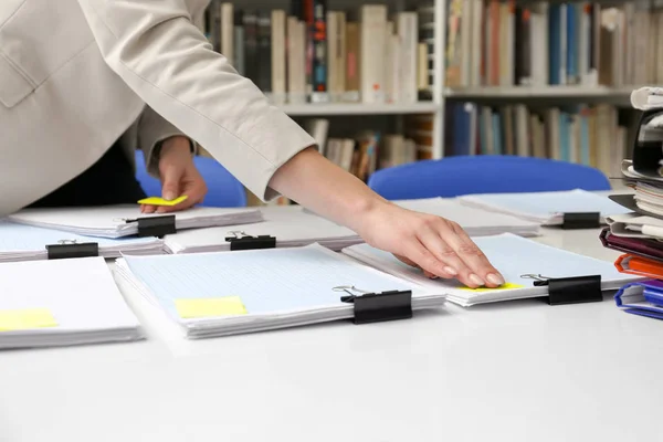 Mulher trabalhando com documentos à mesa no arquivo — Fotografia de Stock