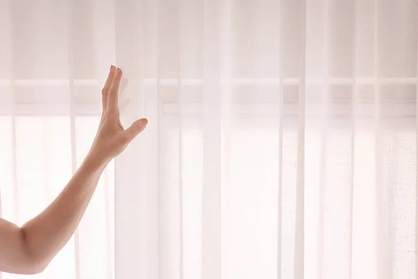 Frau öffnet weiße Vorhänge — Stockfoto