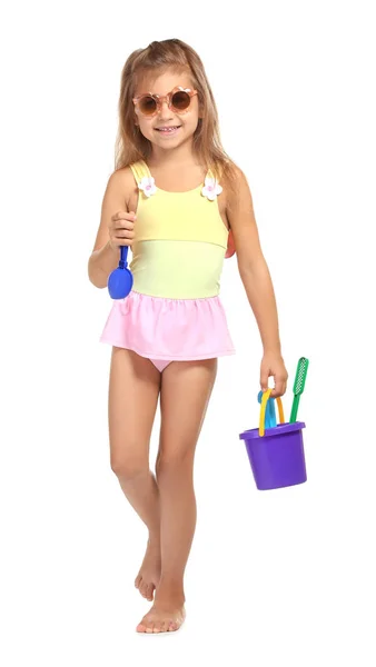 Sevimli küçük kız mayo ile beyaz arka plan üzerinde plastik oyuncaklar — Stok fotoğraf