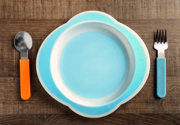 Яскравий дитячий посуд на столі — стокове фото