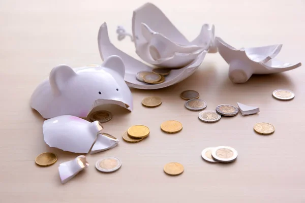 Banco piggy quebrado com moedas no fundo claro — Fotografia de Stock