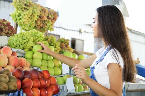 Jeune femme qui choisit des fruits au marché — Photo