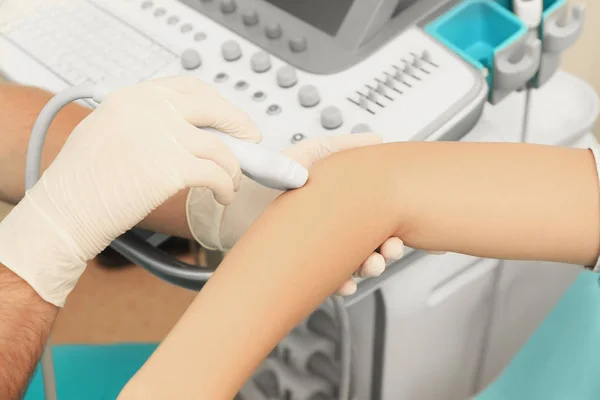 Doctor conducting ultrasound examination of patient's elbow in clinic — Stock Photo, Image