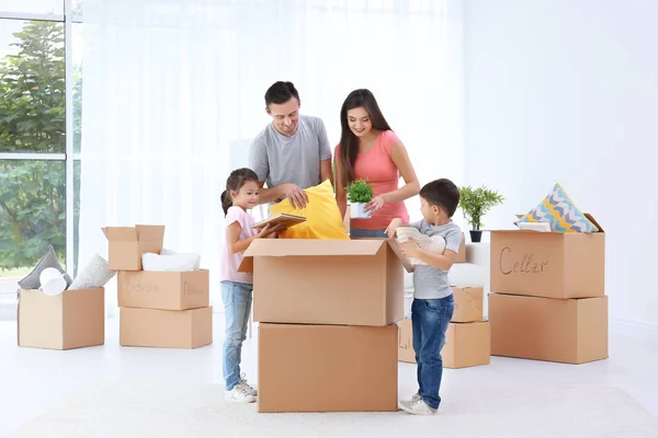 Familia feliz desempacar cajas móviles en la habitación en el nuevo hogar —  Fotos de Stock