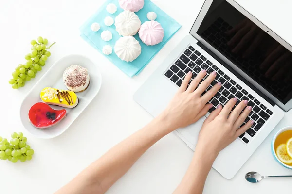 Händerna på matbloggare med laptop och olika produkter på vitt bord — Stockfoto
