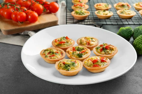 Plaat met broccoli quiche tartlets op tafel — Stockfoto