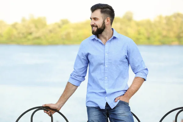 Bonito homem em roupas casuais perto do rio — Fotografia de Stock