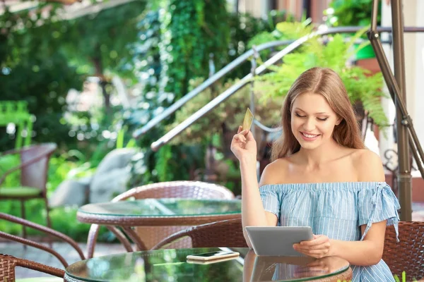 Giovane donna con tablet e carta di credito nel caffè — Foto Stock