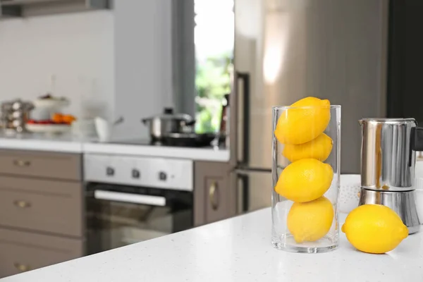Limones y cafetera en la mesa en la cocina moderna — Foto de Stock