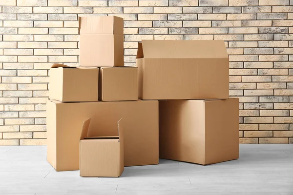 Mover concepto de casa. Cajas de cartón en el suelo en habitación vacía —  Fotos de Stock