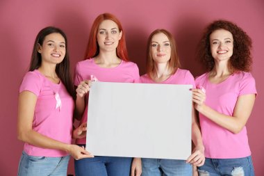 Pembe t-shirt boş kağıdın üzerinde tutan genç kadınlarda arka planını renklendirin. Meme Kanseri Bilinçlendirme kavramı