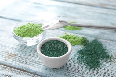 Spirulina ve arpa çim toz kase ahşap arka plan üzerinde
