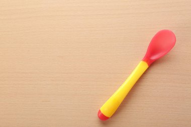 Ahşap masa üzerinde bebek için renkli kaşık