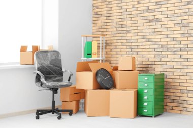 Office move concept. Carton boxes and furniture in empty room clipart