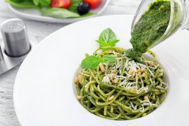 Fesleğen pesto sos makarna üzerine tabak içinde dökme