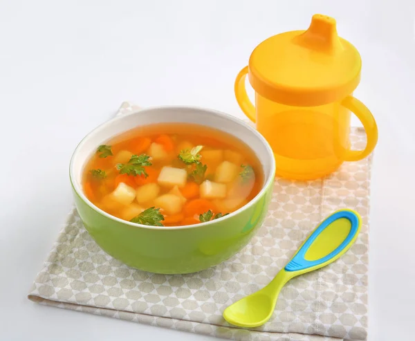 Состав с супом для малыша на белом фоне — стоковое фото