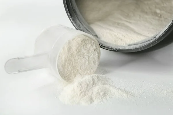 Proteinpuder und Schaufel auf weißem Hintergrund — Stockfoto