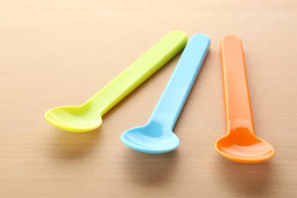 Peralatan makan berwarna-warni untuk bayi di atas meja kayu — Stok Foto