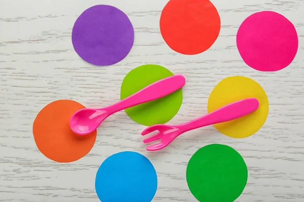 Colorful eating utensils for baby on wooden table — Stock Photo, Image