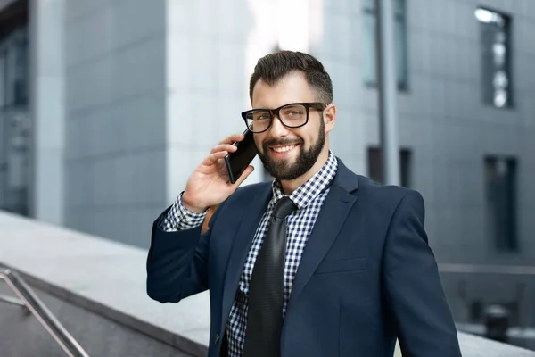 Knappe succesvolle zakenman praten op mobiele telefoon buitenshuis — Stockfoto