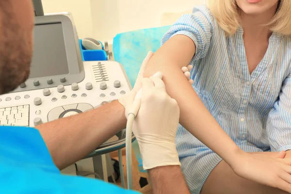 Doctor conducting ultrasound examination of patient's elbow in clinic — Stock Photo, Image