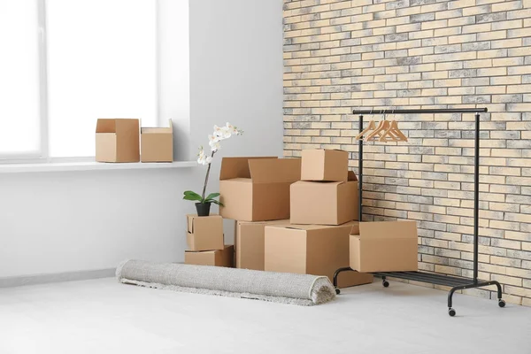 Mover concepto de casa. Cajas de cartón en el suelo en habitación vacía — Foto de Stock