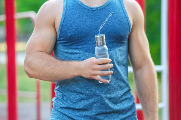 Sportieve jongeman met flesje water, buiten — Stockfoto