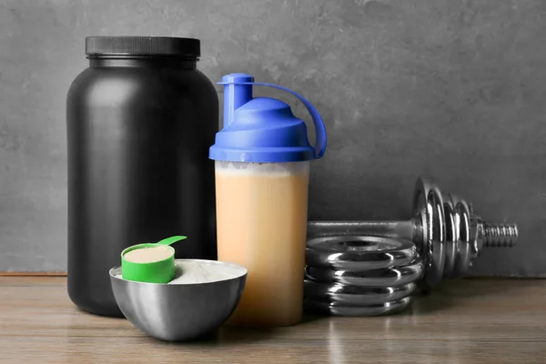 Protein içeceği, toz ve halter masada kompozisyonu — Stok fotoğraf