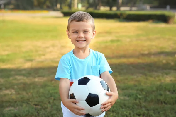 Милый маленький мальчик держит мяч на открытом воздухе — стоковое фото