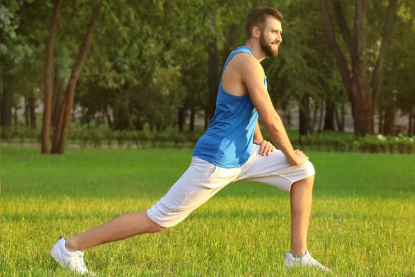 Bello giovane uomo che si esercita nel parco — Foto Stock