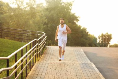 yakışıklı genç adam parkta koşu